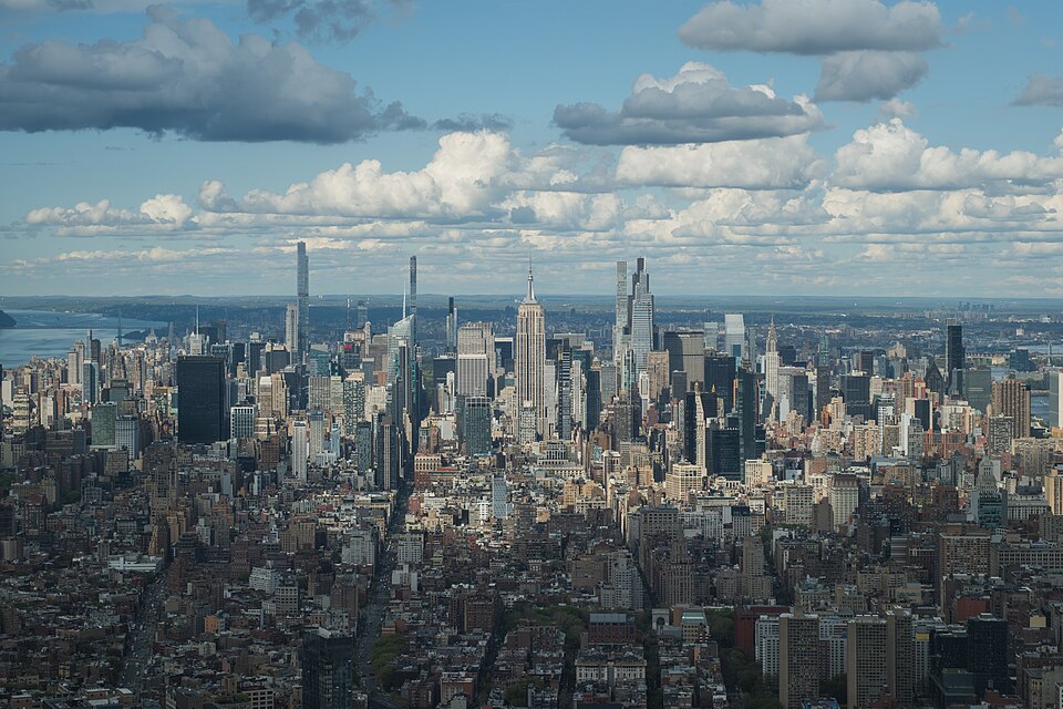 Midtown Manhattan’s skyline with the Empire State Building beneath a cloud-filled sky.